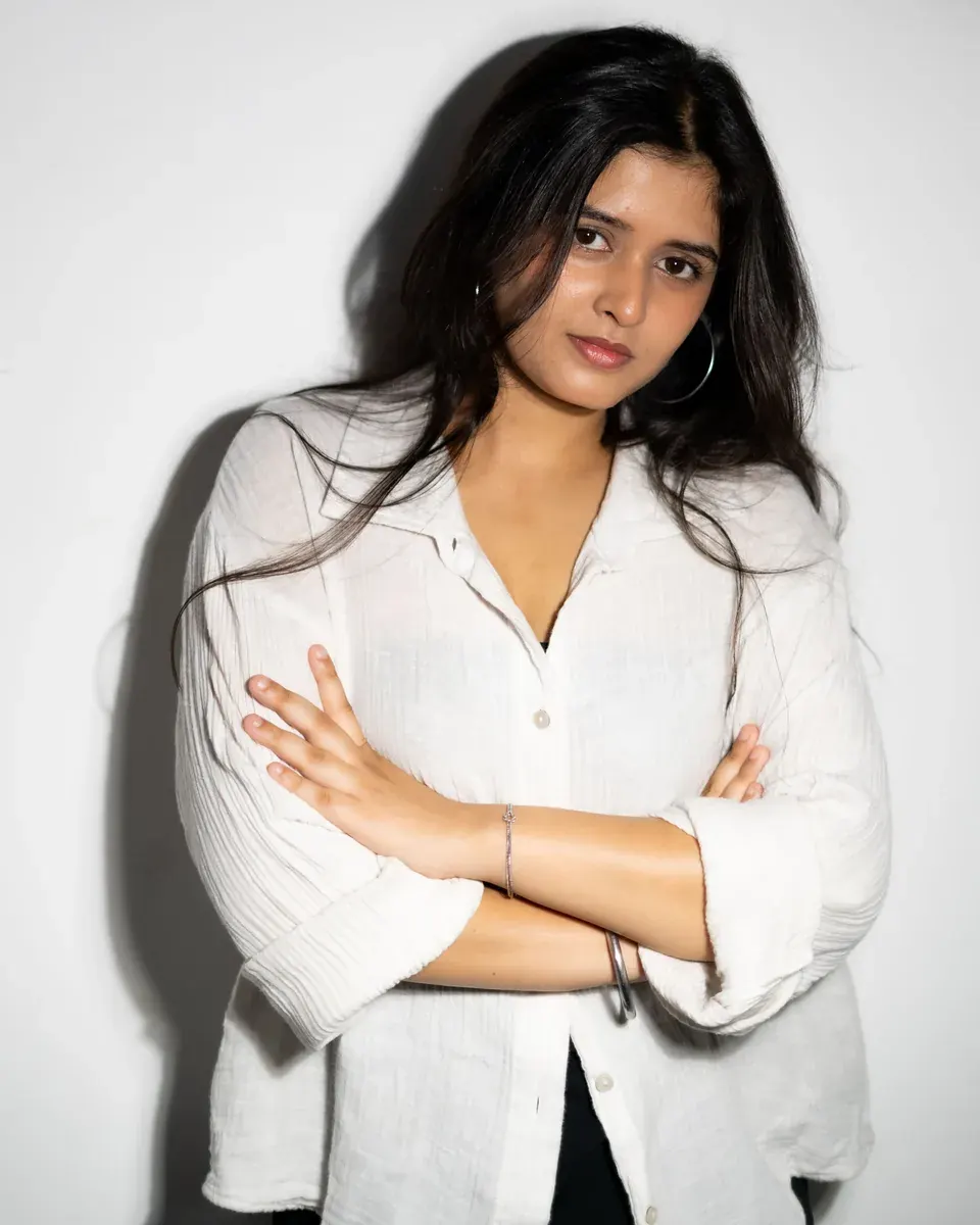 Original photo of a woman with flat, even studio lighting against a plain wall